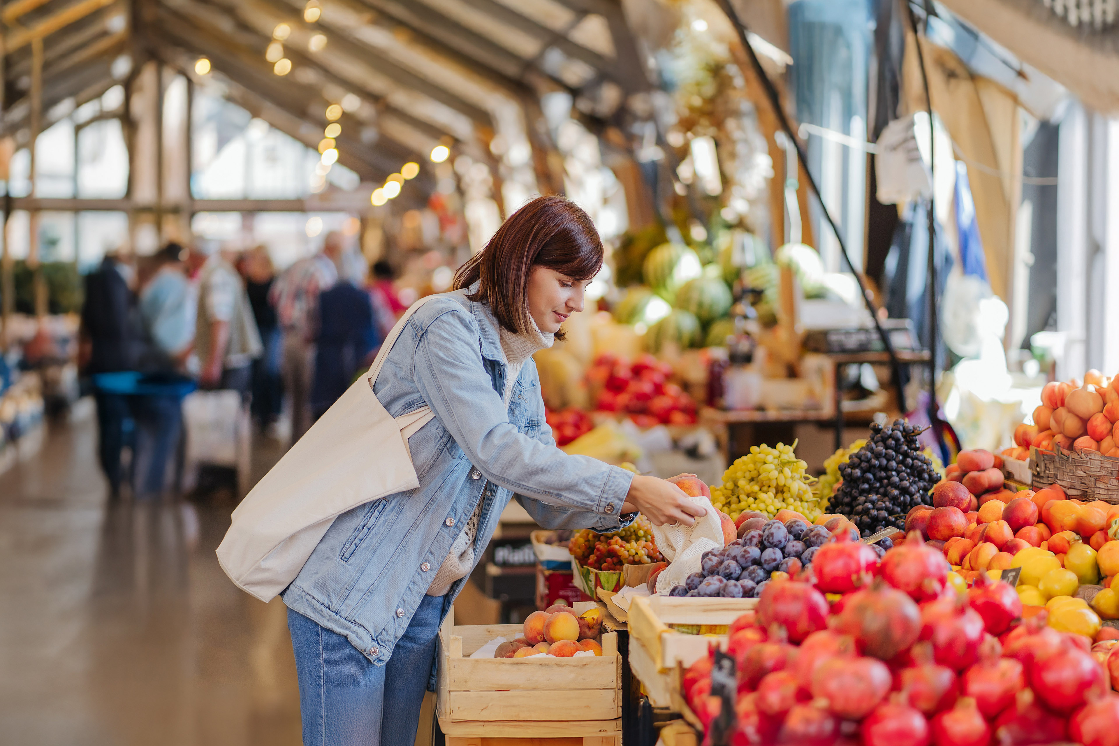 Woman is chooses fruits and vegetables at food market.