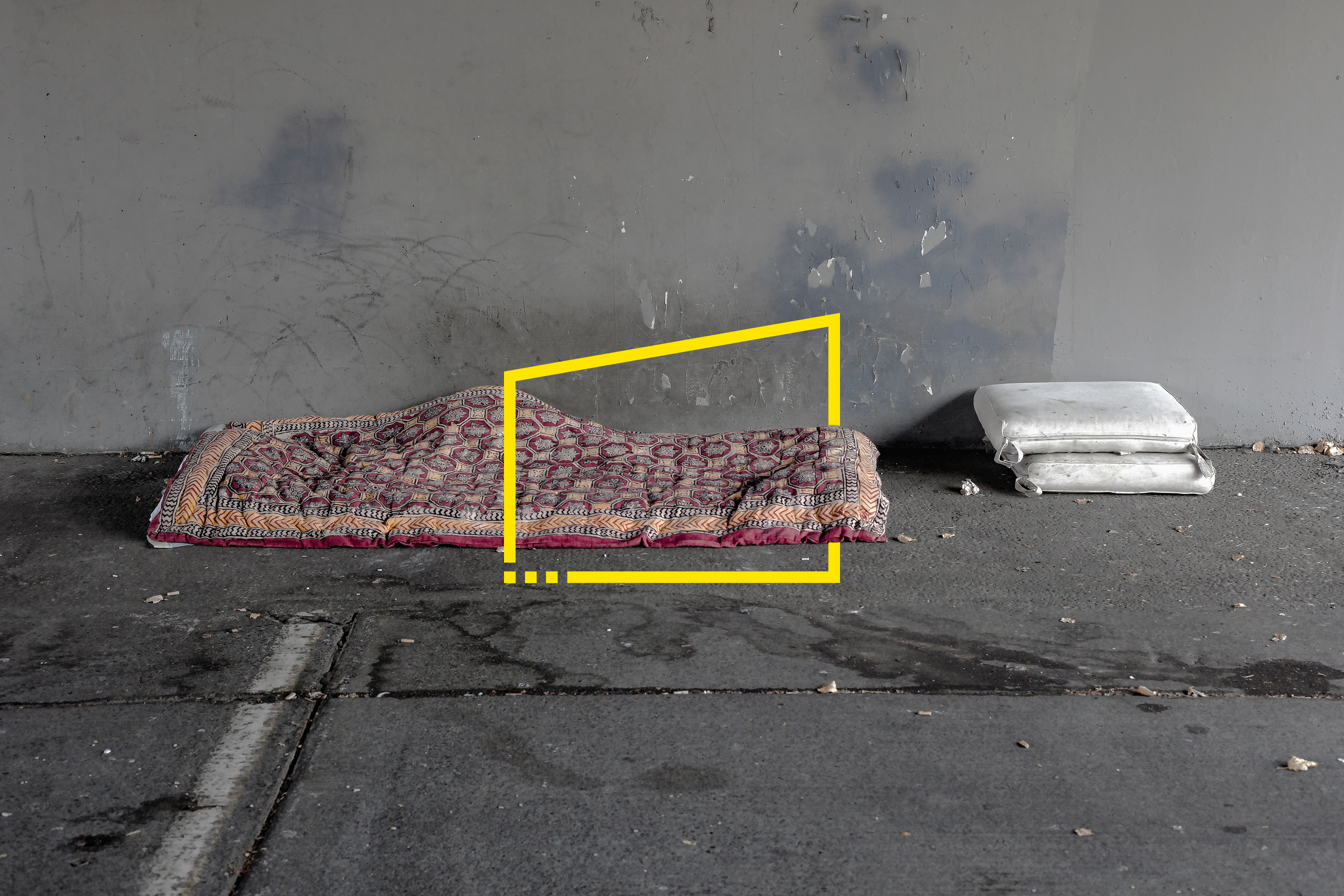 Homeless persons bed and pillows under bridge
