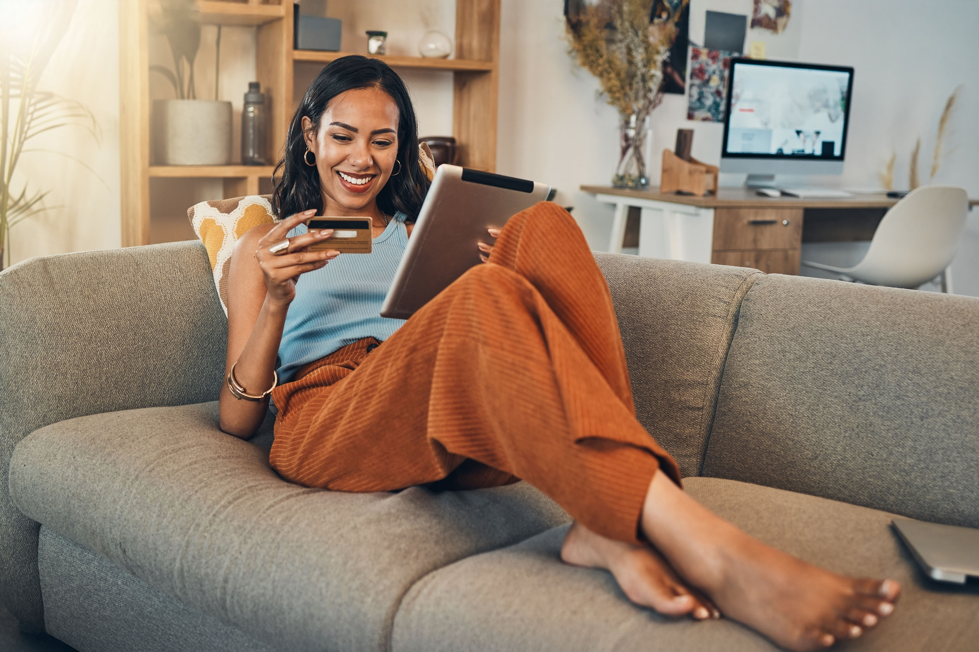 Woman on sofa with tablet credit card and online shopping of fintech payment on ecommerce at home